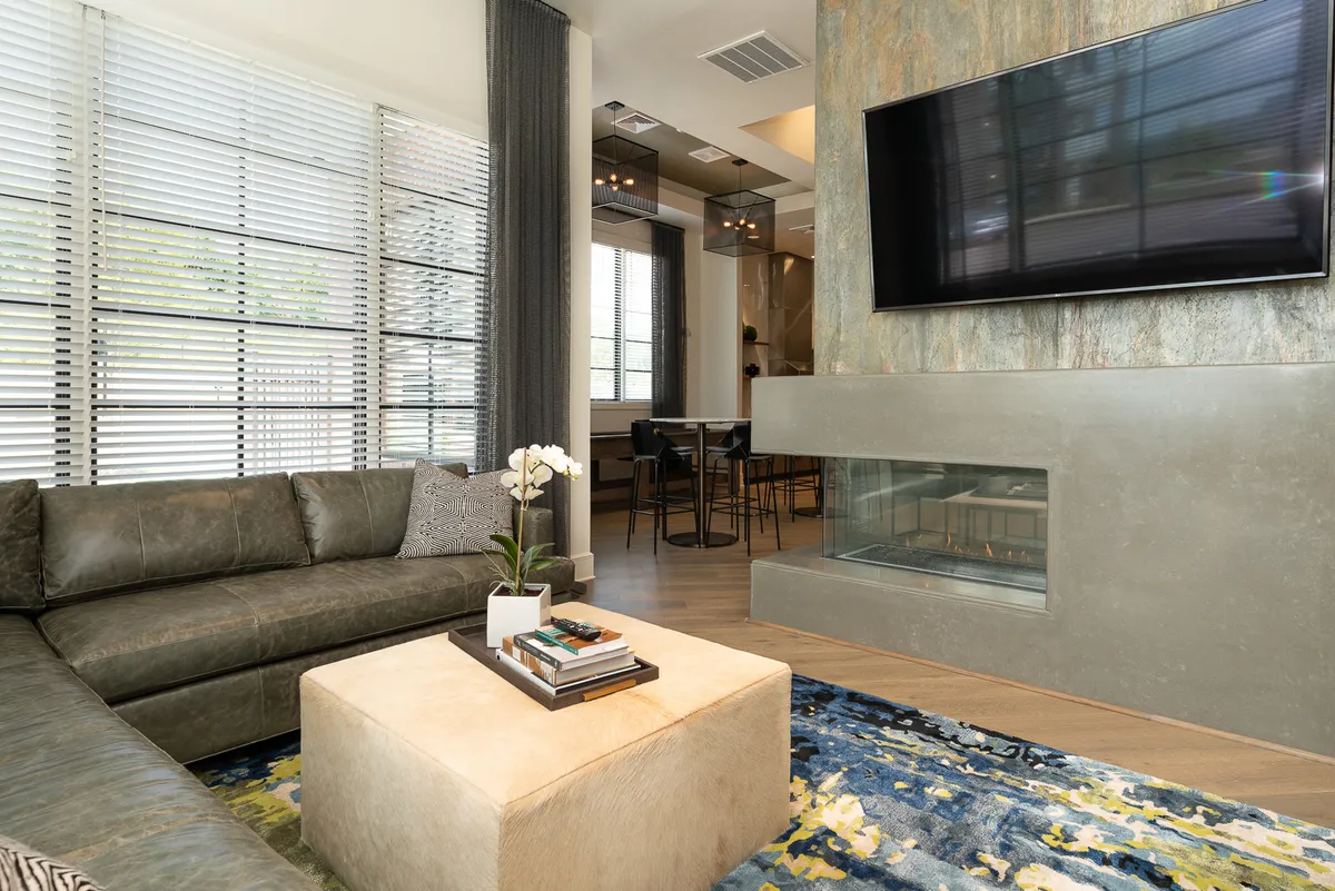 A contemporary living room with a comfortable sofa, coffee table, television, and a cozy fireplace. The ambiance is warm and inviting, providing an ideal space for relaxing after a night out or hosting intimate gatherings.